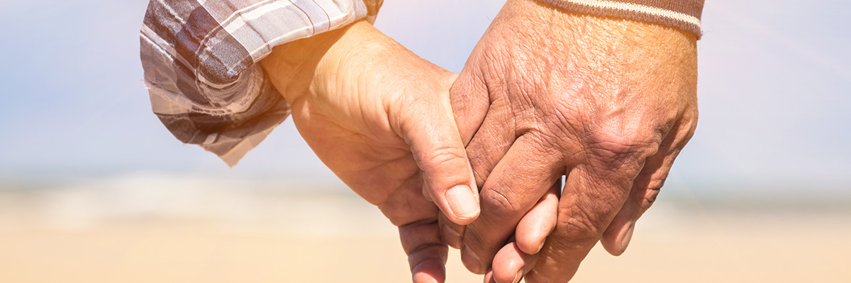 elderly hand holding younger person's hand