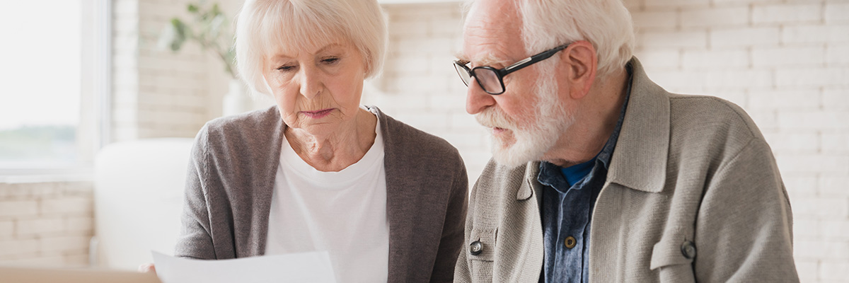 Elderly man and woman looking at documents